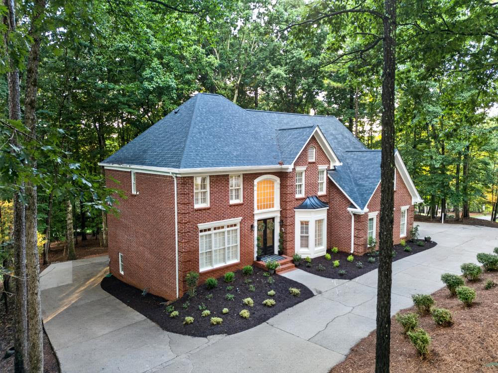 A brick home with a cleaned driveway by KM Property Restorations